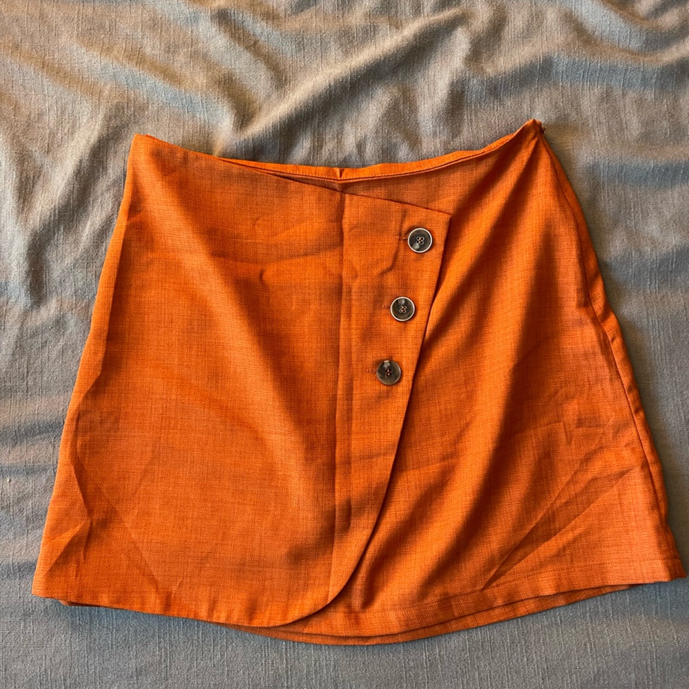 Burnt orange skirt with buttons. Zips up on the side